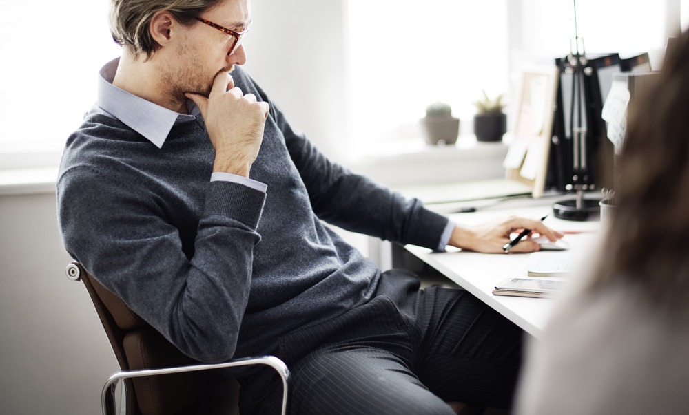 Self-Reflection and Career Goals: An image of a person sitting at a desk, reflecting deeply with a large sketch pad in front of them.